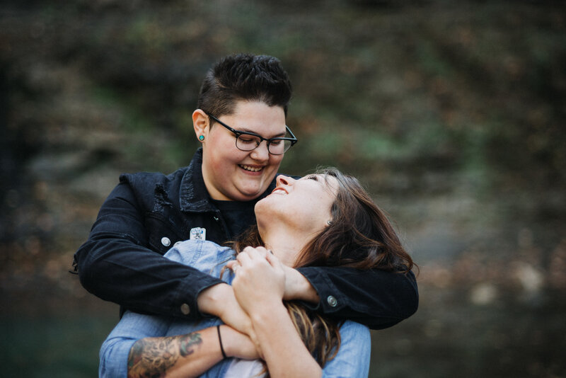 Jade and Ariel engagement portrait at Twin Falls in Arkansas with rainy weather, wet textures, and moody cinematic light