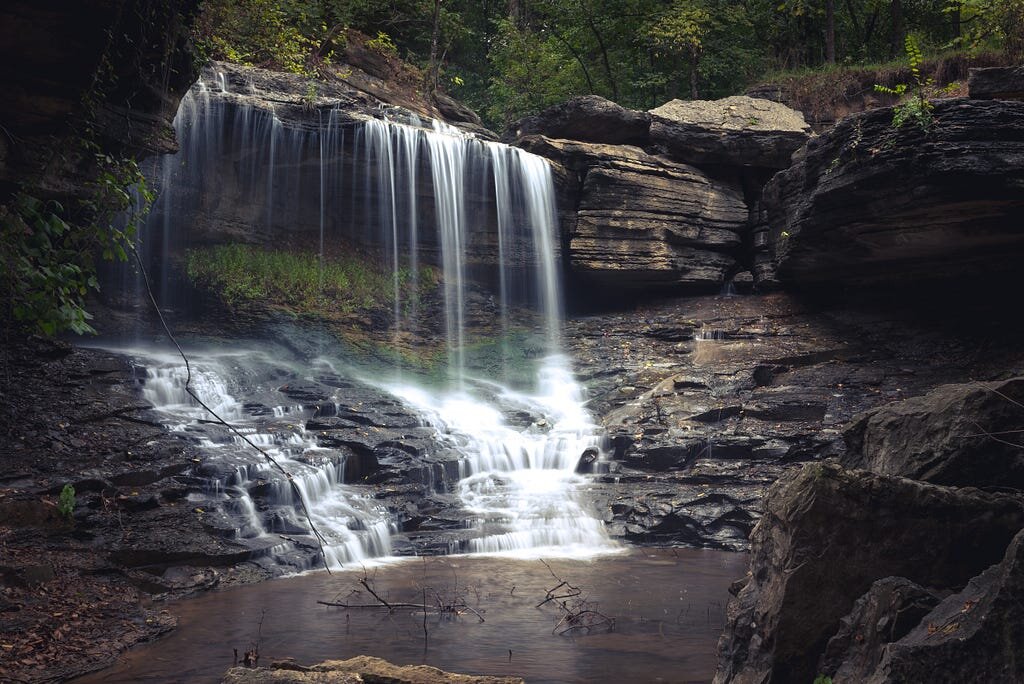 Lake Ann Waterfall in Bella Vista Arkansas framed by mossy rocks and trees