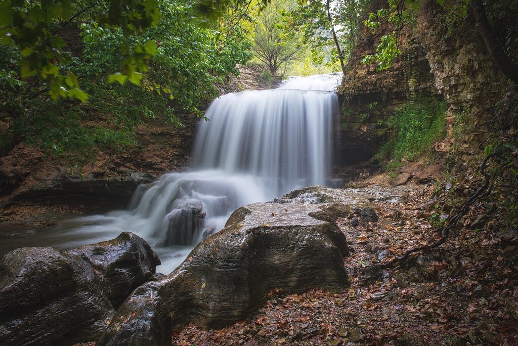 Tanyard Creek Waterfall in Bella Vista Arkansas flowing over broad rock shelves