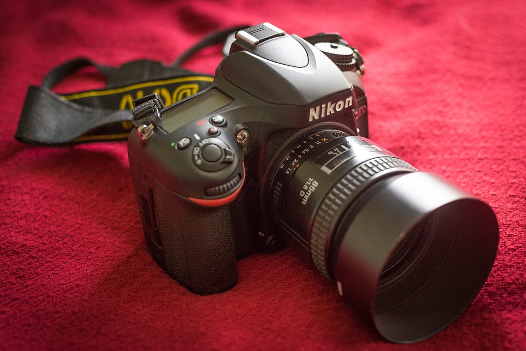 Nikon D610 full frame camera resting on outdoor stone surface