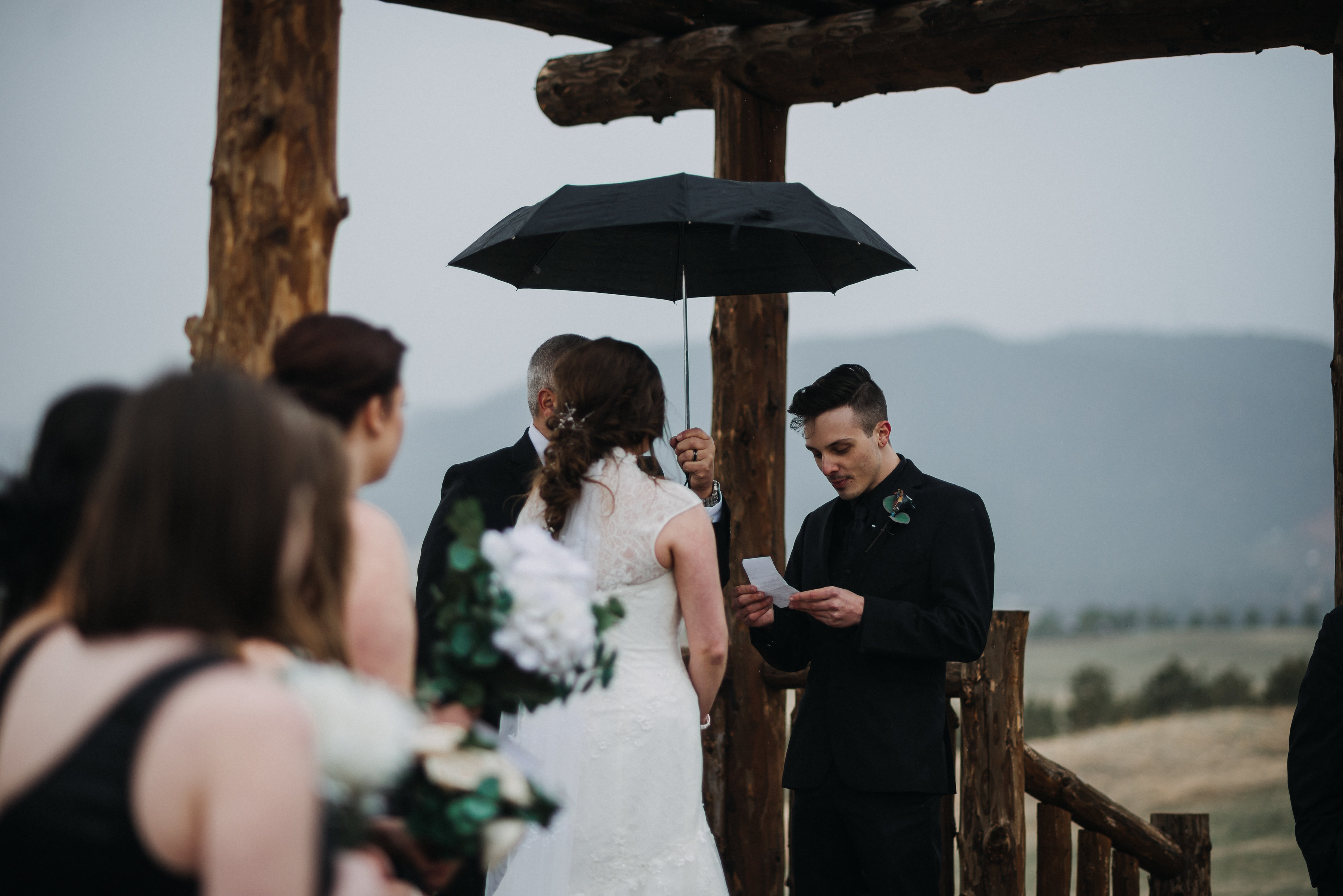 Groom reading vows during a rainy Spruce Mountain Events wedding ceremony in Colorado