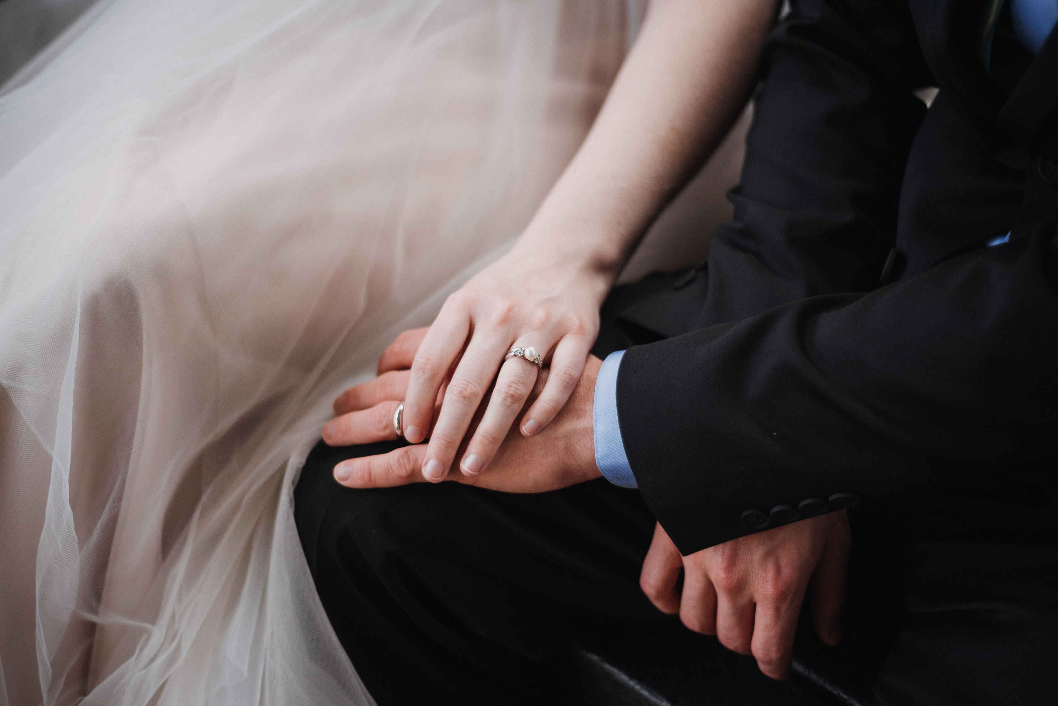 Close-up of Laurel and Andrew wedding rings with pearl engagement ring at Inn at Carnall Hall in Fayetteville Arkansas