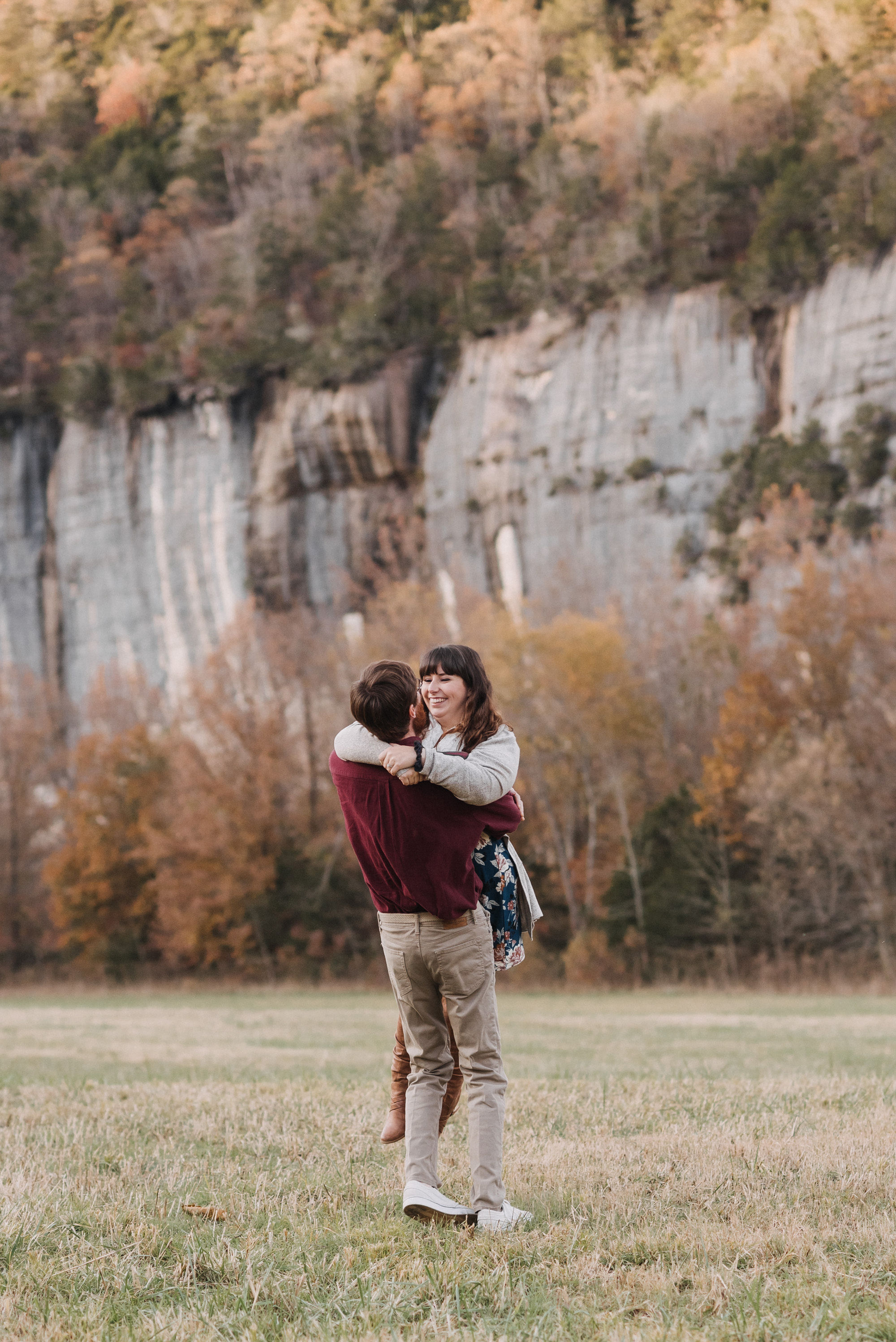 Matt lifting Carmen below the limestone bluffs during their Steel Creek engagement session near Jasper Arkansas