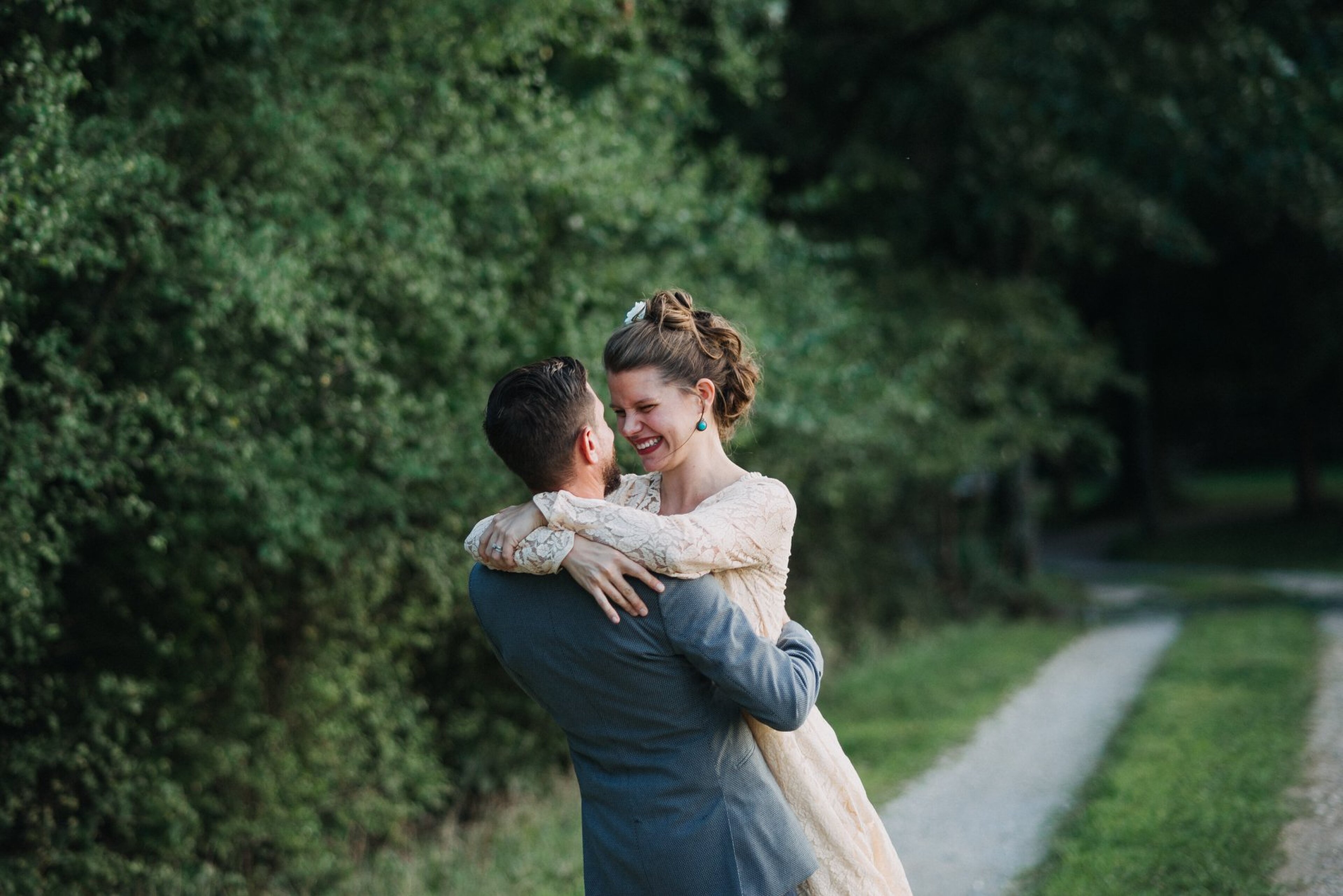 Candid embrace between partners during an intimate wedding ceremony in soft natural light